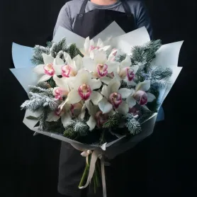 букет из белых орхидей цимбидиум и нобилиса в светлой упаковке