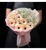 букет из персиковых гербер и белой гипсофилы в розовой упаковке.