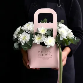 Композиция из белых кустовых хризантем и эвкалипта в розовом плайм-пакете
