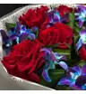 букет из красных французских роз и сине-фиолетовых орхидей с декоративной зеленью в упаковке
