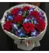 букет из красных французских роз и сине-фиолетовых орхидей с декоративной зеленью в упаковке
