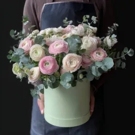 21 белых и розовых ранункулюсов с эвкалиптом в коробке