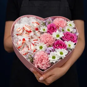 композиция из розовых роз, розовых гвоздик, белых кустовых хризантем, сиреневой альстромерии и конфет Raffaello в коробке в форме сердца