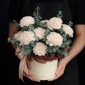 композиция из кремовых гвоздик с эвкалиптом в коробке