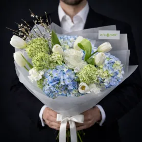букет из голубых и зелёных гортензий, белых тюльпанов, белой гвоздики и декоративных веток