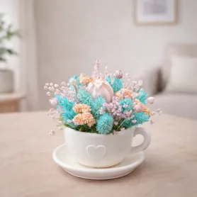 букет из бирюзовых, розовых и бежевых сухоцветов в чашке
