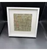 картина из серо-зелёных листьев и белых сухоцветов в белой рамке