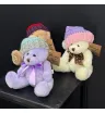 мягкая игрушка медвежонок бежевого, сиреневого и молочного цвета в вязаной шапке