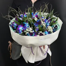 букет из синих орхидей дендробиум и белой гипсофилы в светлой упаковке