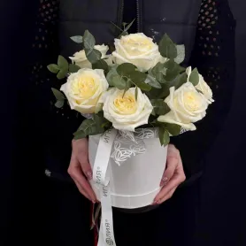 белые эквадорские розы с эвкалиптом в розовой шляпной коробке