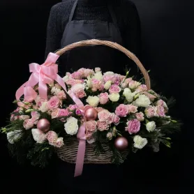композиция из роз, эустомы, гвоздик, хвойной зелени и розовых декоративных шаров в корзине