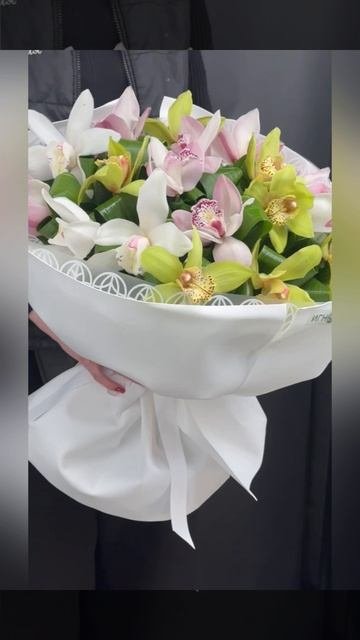 букет из белых,розовых и зелёных орхидей цимбидиум с декоративной зеленью в белой упаковке