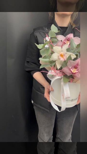 композиция из кремовых и розово-сиреневых орхидей цимбидиум с эвкалиптом и декоративными веточками в коробочке