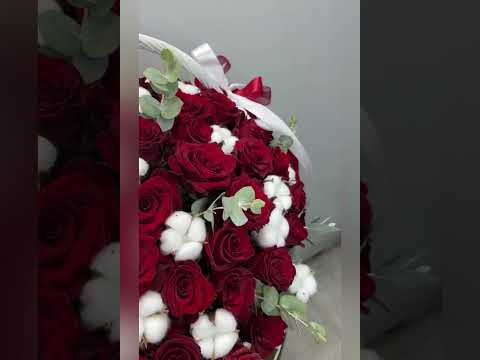 композиция из красных роз, хлопка и эвкалипта в белой корзине