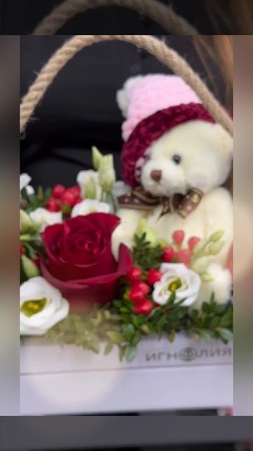 композиция с мягкой игрушкой, белыми цветами, красными декоративными элементами и зеленью в деревянном ящике