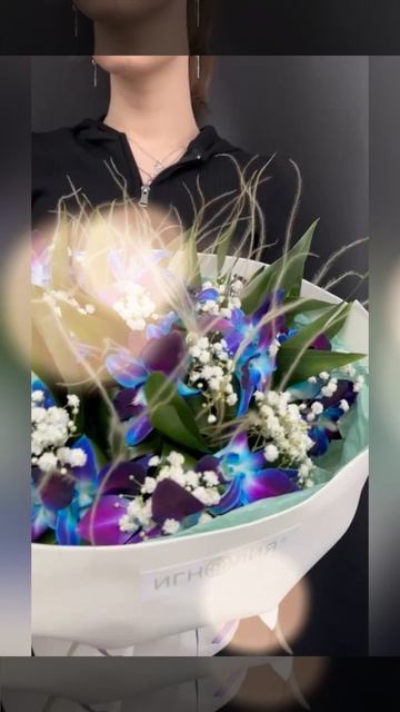 букет из синих орхидей дендробиум и белой гипсофилы в светлой упаковке