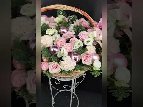 композиция из роз, эустомы, гвоздик, хвойной зелени и розовых декоративных шаров в корзине