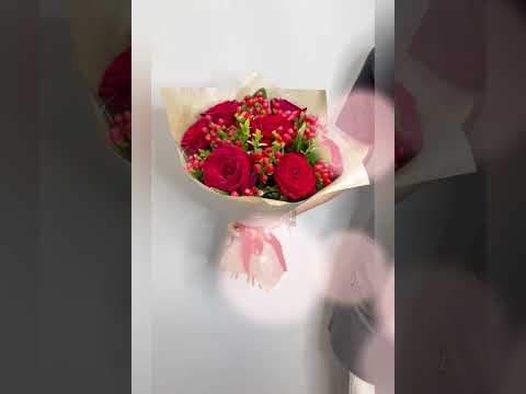 красные розы и гиперикум в букете.